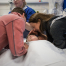 Mother and father leaning over their son in a hospital bed